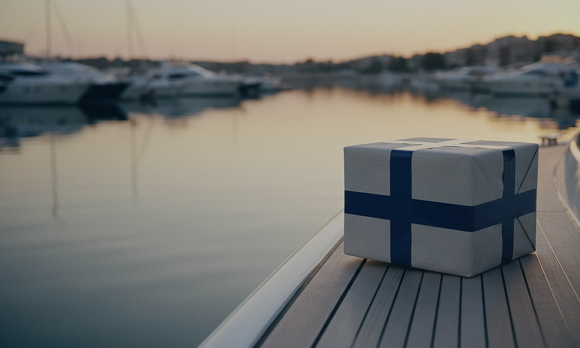 Luxury package wrapped in linen with navy ribbon resting on a yacht deck at sunset, symbolizing YPC’s precise and effortless return service.