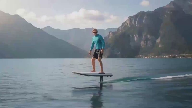 A young man riding on water the Flyer EVO Electric Hydrofoil while another man is flying waterproof SwellPro drone from yacht deck - Onboard Lifestyle Collection by Yacht Protection Concepts