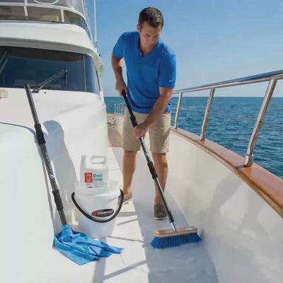Essential Boat Cleaning System demonstration video showing yacht owner using Yot Stik telescoping brush, Shurhold deck brush, and Lat 26 boat soap to clean white yacht deck and teak surfaces - complete 5-piece bundle in action.