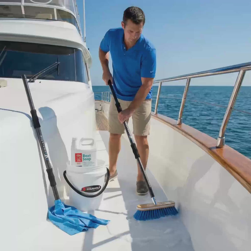 Essential Boat Cleaning System demonstration video showing yacht owner using Yot Stik telescoping brush, Shurhold deck brush, and Lat 26 boat soap to clean white yacht deck and teak surfaces - complete 5-piece bundle in action.